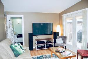 uma sala de estar com uma grande televisão de ecrã plano em Hidden Treasure in the Heart of Port Stanley em Port Stanley
