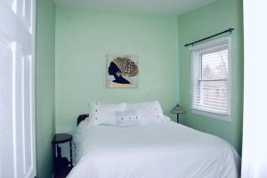 1 dormitorio con cama blanca y ventana en Hidden Treasure in the Heart of Port Stanley, en Port Stanley