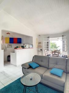 een woonkamer met een bank en een tafel bij F3 Résidence LE 25 ex PANORAMA in Les Trois-Îlets