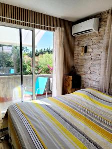 1 dormitorio con cama y ventana grande en Charmante maisonnette proche plage en Fréjus