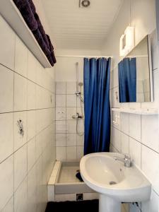 a bathroom with a sink and a blue shower curtain at F3 Résidence LE 25 ex PANORAMA in Les Trois-Îlets