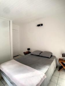 um quarto com uma cama e uma luz na parede em F3 Résidence LE 25 ex PANORAMA em Les Trois-Îlets