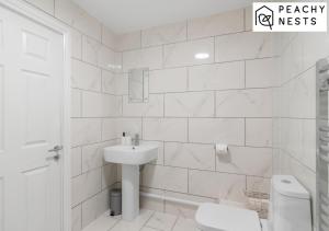 a white bathroom with a sink and a toilet at Superb 2 Bed Close to City Center Sleeps 5 with Parking in Norwich
