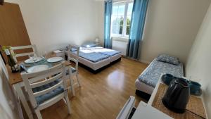 a small room with two beds and a table and a dining room at Kwatery Mielenko Patraj in Mielenko