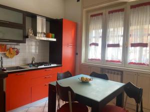 a kitchen with red cabinets and a table with a bowl of fruit on it at Casa Fortuna - Intero alloggio al centro di Cava in Cava deʼ Tirreni