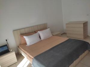 a bedroom with a bed with two pillows and a laptop at COMFY CITY CENTER APARTMENT in Shkodër