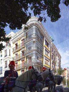 three people on horses in front of a building at Aparthotel ARDMADRID Centro in Madrid