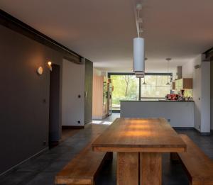 una sala da pranzo con tavolo in legno e una cucina di Maison Anthica a Gesves