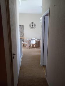 un couloir avec une chambre avec une horloge sur le mur dans l'établissement Le Cocoon de Py - Superbe T2 au calme avec garage, à Bagnères-de-Bigorre