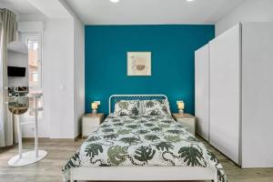 a bedroom with a blue wall and a bed at Umihouse apartamentos centro Alicante in Alicante
