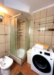 a washing machine in a bathroom with a shower at Baroque-style apartment in Štip +13 photos