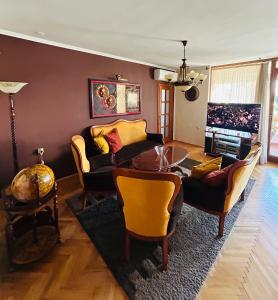 een woonkamer met een bank, stoelen en een tafel bij Baroque-style apartment in Štip