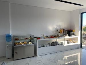 a kitchen with two shelves filled with food at Sunlight Hotel in Ksamil