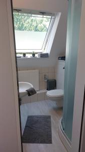 ein kleines Badezimmer mit Toilette und Fenster in der Unterkunft Parva Domus in Xanten