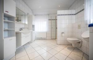uma casa de banho branca com um WC e um lavatório em Luxe woning 14 pers 6 slaapkamer 