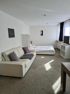 a living room with a couch and a bed at FeWo D'Rock Arosa im Zentrum by Nature Apartments Switzerland in Arosa
