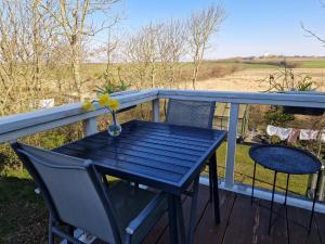 a blue table and chairs on a deck with a view at Nationalpark Thy guesthouse in Vestervig