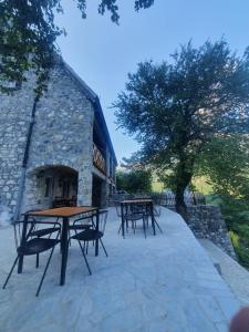 a group of picnic tables in front of a stone building at Villa Davisol in Theth