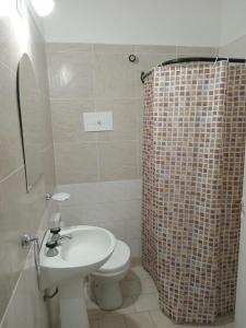 uma casa de banho com um WC, um lavatório e um chuveiro em Dpto Saavedra em Tres Arroyos