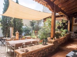 eine Terrasse mit einem langen Tisch und Stühlen in der Unterkunft Oasis de Ifre in Cañada de Gallego