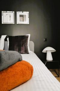 - une chambre avec un lit recouvert d'une couverture orange dans l'établissement Cloître de la Barge - Le Charmant - 2 min Centre Ville & Cathedrale, à Amiens