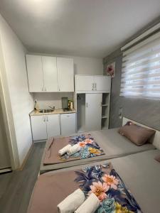 a small room with two beds and a kitchen at Apartments Glitter in Mostar