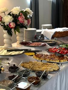 a table with a buffet of food and flowers at Villa Livia Boutique Apartments in Ravda