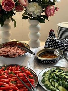 Villa Livia Boutique Apartments في رافدا: طاولة مع أطباق من الطعام و مزهرية مع الزهور