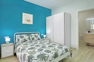 a blue bedroom with a bed and a blue wall at Umihouse apartamentos centro Alicante in Alicante