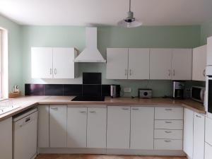 a kitchen with white cabinets and a counter top at Stable Cottage at Orchard Farm in Combles