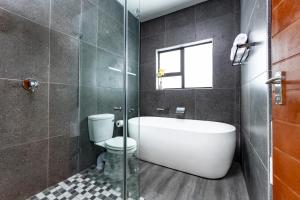 een badkamer met een toilet en een glazen douche bij Panorama Boutique Guest House in Graskop
