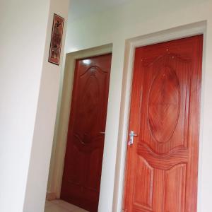 two wooden doors in a room next to each other at Mileslin Homes in Machakos