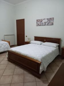 1 dormitorio con 1 cama grande con sábanas blancas en Casa Teresa, en Tarquinia