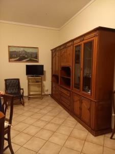 un soggiorno con un grande armadio in legno e una TV di Casa Teresa a Tarquinia