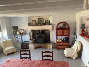 a living room with a fireplace and a table and chairs at La Maison de Josephine in Montignac-Charente