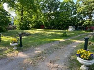 zwei Steinvasen mit Blumen auf einer unbefestigten Straße in der Unterkunft Kläckeberga Bed Not Breakfast in Kalmar