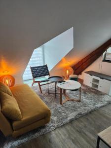 a living room with a couch and a table at Gîte des granges in Alençon