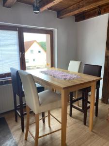 a dining room table with chairs and a table and a window at Haus Monika in Homburg