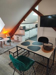 a living room with a table and chairs and a kitchen at Gîte des granges in Alençon