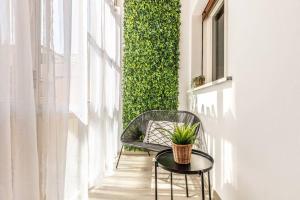 una silla y una mesa en un balcón con una planta en Belmeloro Home en Bolonia