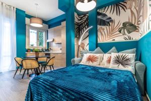 ein blaues Schlafzimmer mit einem Bett und einem Tisch in der Unterkunft Belmeloro Home in Bologna