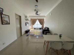 een woonkamer met een bank en een tafel en stoelen bij Homestay Shah Rizki@Bali Resident Melaka-muslim friedly in Melaka