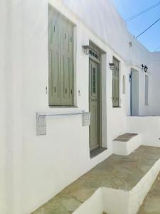 un edificio blanco con puertas verdes y un patio en Iris house, en Apollonia