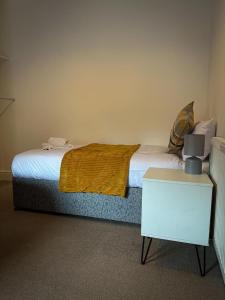 ein Schlafzimmer mit einem Bett mit einem Nachttisch und einem Bett sidx sidx sidx sidx sidx in der Unterkunft The Beatles house - Penny Lane - Contractors -Relocating in Liverpool