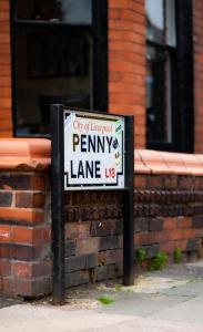 ein Schild vor einem Backsteingebäude in der Unterkunft The Beatles house - Penny Lane - Contractors -Relocating in Liverpool