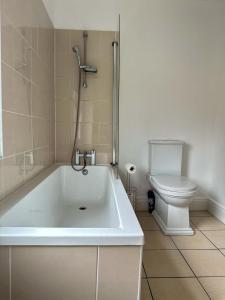 ein Badezimmer mit einer weißen Badewanne und einem WC in der Unterkunft The Beatles house - Penny Lane - Contractors -Relocating in Liverpool