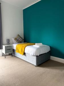 Schlafzimmer mit einem Bett mit blauer Wand in der Unterkunft The Beatles house - Penny Lane - Contractors -Relocating in Liverpool