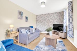 sala de estar con sofá y TV en Contractors Retreat 3 bed house, sleeps up to 7, free parking en Milton Keynes