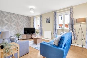 sala de estar con sofá azul y TV en Contractors Retreat 3 bed house, sleeps up to 7, free parking en Milton Keynes