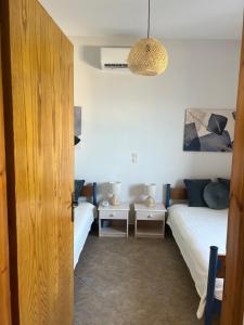 una camera con due letti e una luce a ciondolo di Ninemia Apartment a Kali Limenes